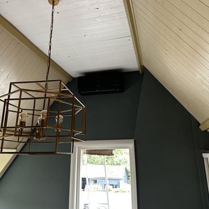 Een luchtconditioningsunit geïnstalleerd aan het plafond in een stijlvolle kamer.
