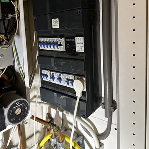 De afbeelding toont een meterkast met elektrische componenten, die vaak gebruikt worden in zonnepaneleninstallaties voor de distributie van opgewekte energie.
