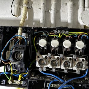 De afbeelding toont een elektrische meterkast met diverse aansluitingen en schakelaars voor een zonnepaneleninstallatie.