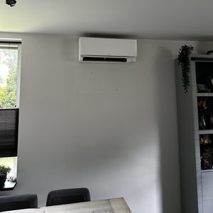 Een recent geïnstalleerde airconditioningseenheid aan de wand van een kamer, met een modern en strak ontwerp.