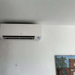 Installatie van een wand-airco-unit, geschikt voor het koelen en verwarmen van een ruimte.