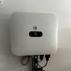 De afbeelding toont een omvormer voor zonnepanelen, met aansluitingen en indicatorlampjes voor werking.