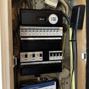 De afbeelding toont een meterkast met schakelaars en bedrading, mogelijk gerelateerd aan een airconditioninginstallatie.