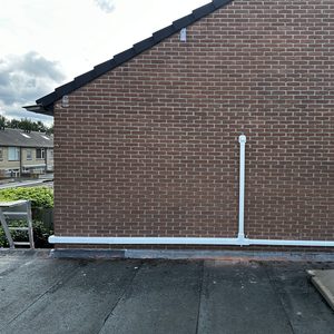 De foto toont een wand met leidingen voor een airconditioninginstallatie, wat wijst op een aanstaande of recente installatie.