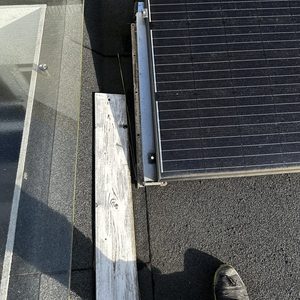 De afbeelding toont een zonnepaneel dat op een dak is geïnstalleerd, met een duidelijk zicht op de structuur en bevestigingen.