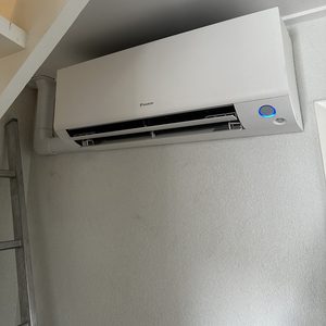 Deze airconditioning is bevestigd aan de muur en biedt koeling voor de ruimte.