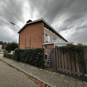De afbeelding toont een gevel van een gebouw met een airco-installatie zichtbaar aan de rechterzijde.