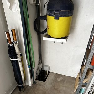 De installatie toont een laadpaal geconfigureerd in een opbergruimte, met zichtbare kabels en aansluitingen voor elektrische voertuigen.