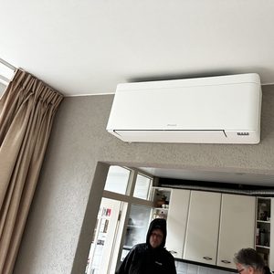 Instalatie van een wandmodel airconditioningseenheid in een keukenruimte.