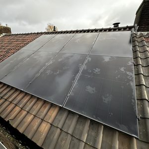 Vijf zonnepanelen zijn geïnstalleerd op een hellend dak. Ze zijn vernieuwend gepositioneerd om optimale zonne-energie te verzamelen.