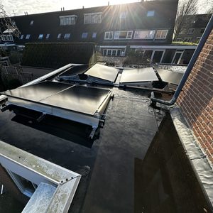 Een installatie van zonnepanelen op een plat dak, gericht op het genereren van zonne-energie voor woninggebruik.
