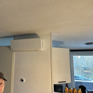 De foto toont een geïnstalleerde airconditioningseenheid aan de muur in een appartement, zichtbaar boven de deuren.