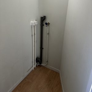 De foto toont een hoek waar elektrische leidingen en aansluitingen zijn geïnstalleerd, waarschijnlijk voor een meterkast of elektrische installatie.