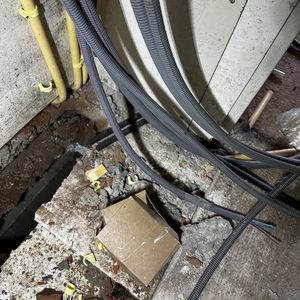 Deze afbeelding toont enkele leidingen en kabels die deel uitmaken van een airconditioning installatie in een bouwomgeving.