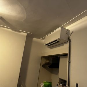 Een wandunit voor airconditioning geïnstalleerd in een kamer, zichtbaar aan de muur met leidingen voor de verbinding.