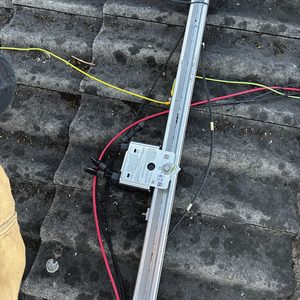 De installatie toont een zonnemodule met bekabeling op een dak, inclusief een omvormer voor het omzetten van zonne-energie.