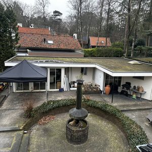 De installatie toont een woning met zonnepanelen op het dak, terwijl er ook gereedschap en materialen voor installatie aanwezig zijn.