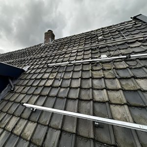 De foto toont een dak met voorgemonteerde rails voor zonnepanelen, klaar voor de installatie van zonnepanelen.