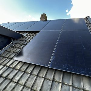 Installatie van zonnepanelen op een hellend dak, zichtbaar met enkele zonnepanelen en een moderne afwerking.