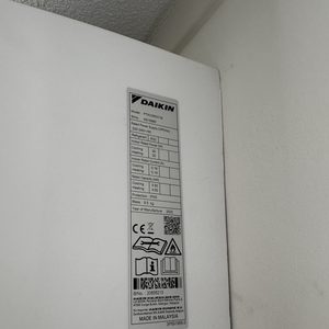 Deze afbeelding toont het naamplaatje van een Daikin airconditioner met specificaties voor koelen en verwarmen.