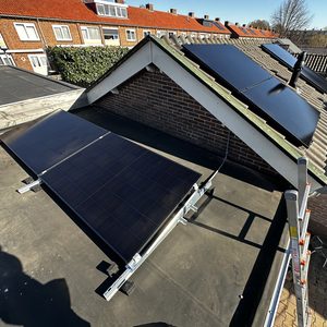Deze installatie toont zonnepanelen die zijn gemonteerd op een hellend dak, met een metalen beugel bevestiging en zichtbare bekabeling.