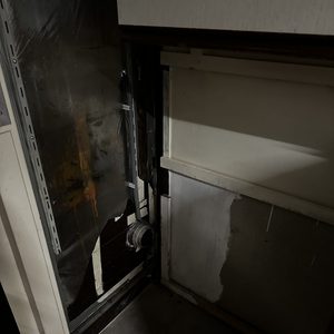De afbeelding toont een meterkast met zichtbare bedrading en componenten, waarbij de verlichting de details niet volledig zichtbaar maakt.