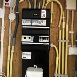 Een meterkast met aansluitingen voor zonnepanelen, uitgerust met een energie-verdelingspaneel en diverse schakelaars.