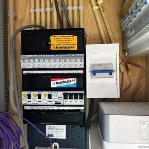 Deze afbeelding toont een meterkast waarin de elektrische aansluitingen voor een laadpaal zijn opgenomen.