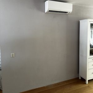 De foto toont een wandgemonteerde airconditioner, ideaal voor het koelen van een binnenruimte.