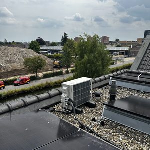 Deze installatie toont een airconditioningseenheid op het dak, naast zonnepanelen en andere componenten.